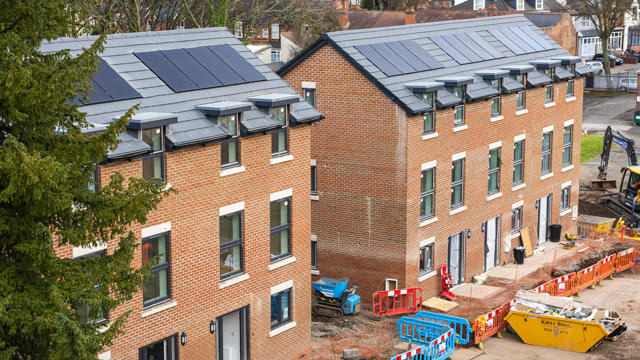A row of houses with 3 floors, with building barriers in front of them