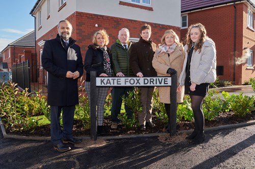Kate's family standing around Kate Fox Drive street sign