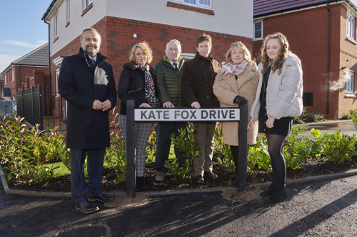 Kate's family standing around Kate Fox Drive street sign