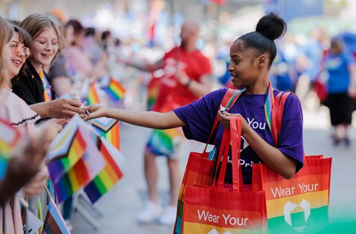 Girl handing out bags at pride