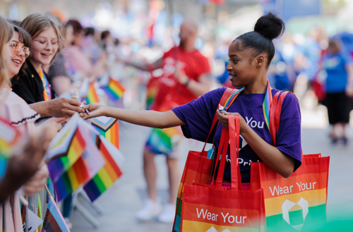 Girl handing out bags at pride