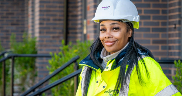 A Midland Heart staff member wearing a high vis jacket and hard hat